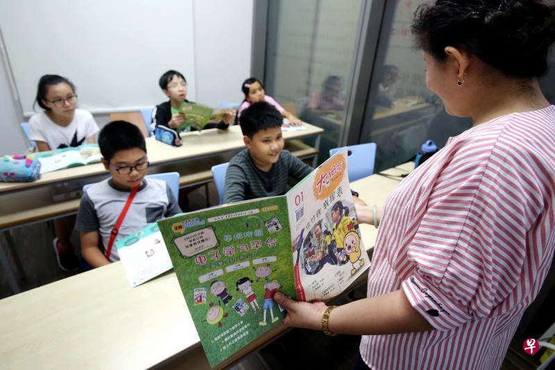 汉文教集团从今年起将读报时间融入每月课程，让学生接触新闻，培养读报习惯。（龙国雄摄）