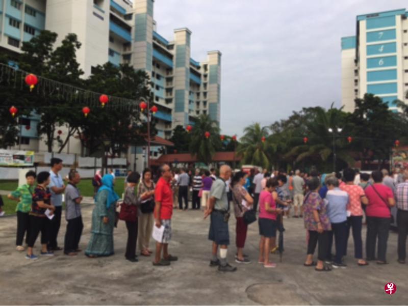 一群年长者在一场社区举办的度岁金颁发活动上，排队领取度岁金。（读者提供）