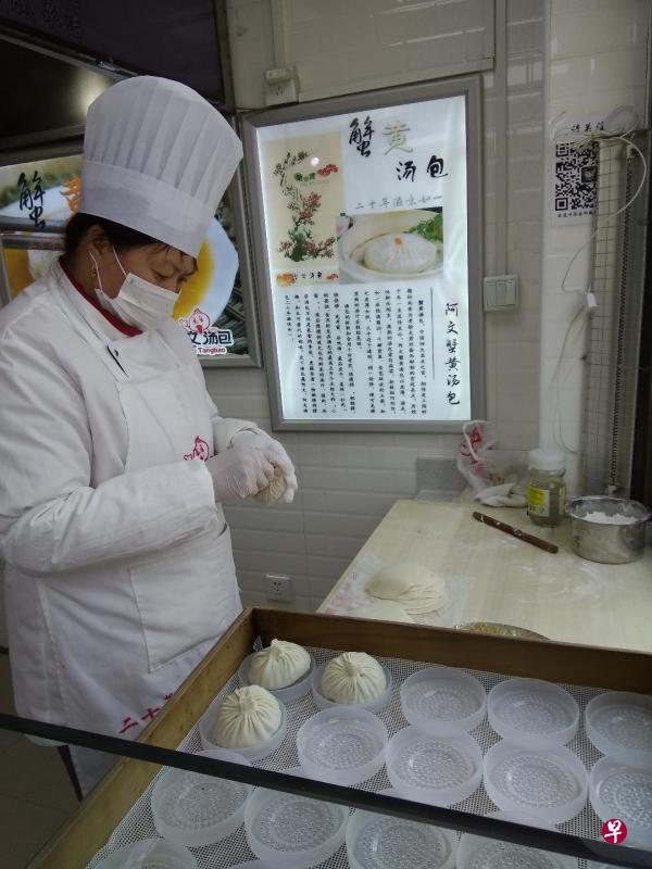 阿文蟹黄汤包的师傅正在示范做包子。