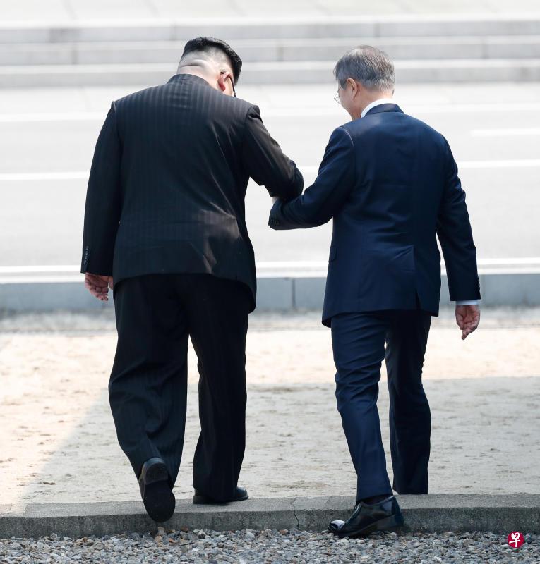 金正恩牵着文在寅的手跨入朝鲜境内。（路透社）