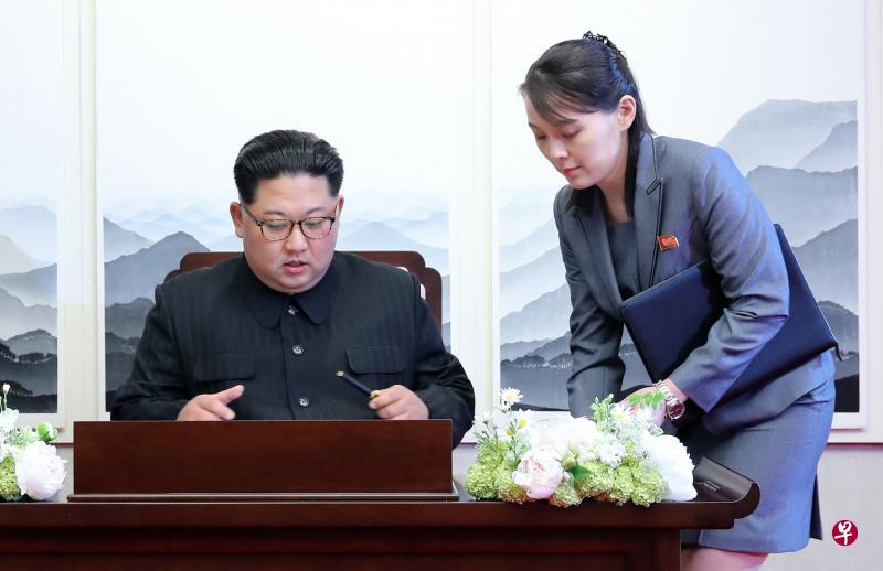 金正恩的妹妹金与正是随行官员，也是哥哥的贴身助理。图为金正恩在和平之家纪念册上留言时，金与正在旁伺候。（彭博社）