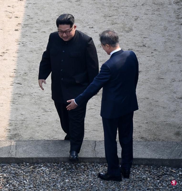 在文在寅的迎接下，金正恩历史性跨过韩朝军事分界线。（彭博社）