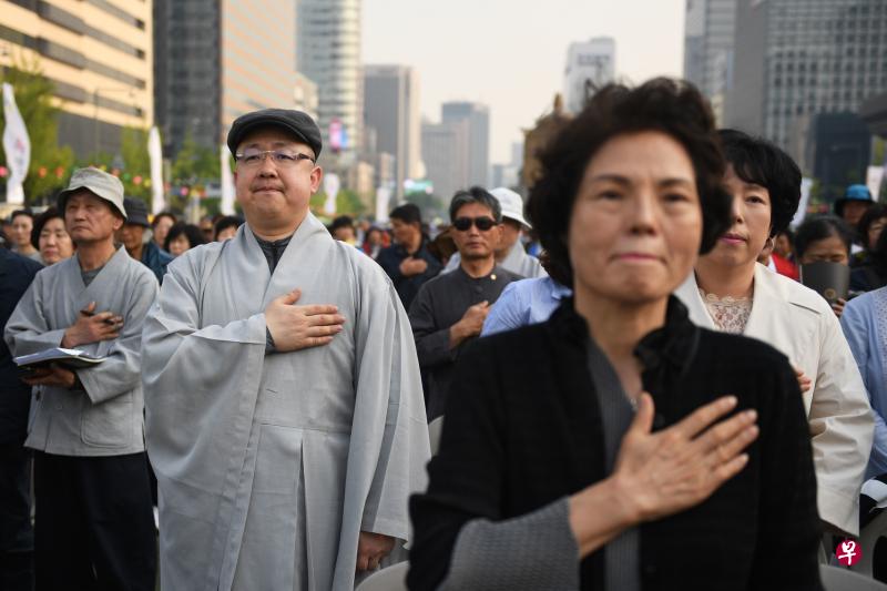 韩国民众对南北领导人会谈寄予厚望，峰会举行时，首尔市中心举办佛教祈福大会，万众一同祈求半岛永久和平。（法新社）