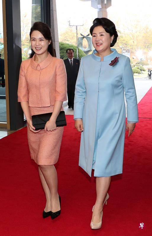在前天的韩朝峰会晚宴上，两位第一夫人衣着有学问，含“暖春”寓意。金正淑（右）穿天蓝色连衣裙加长外套，配上胸针，端庄典雅；李雪主穿桃红及膝套装，长头发半扎，黑手包搭黑鞋，散发简约文雅气质。（法新社）