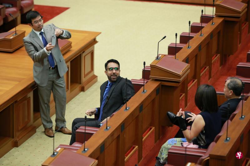 　工人党新秘书长毕丹星（左二）取代前党魁刘程强（右一背对镜头者）坐到国会前排中间位置，白沙—榜鹅集选区议员再纳（左一）在国会开幕式开始前，为毕丹星、刘程强和工人党主席林瑞莲（右二背对镜头者）拍照。（何家俊摄）