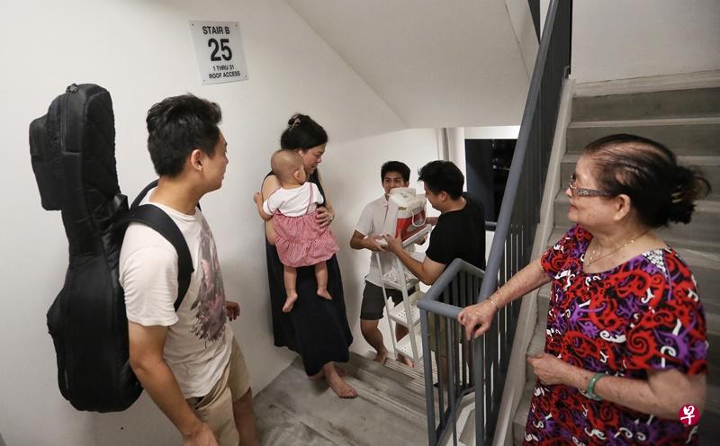 一家八口拿着大小物品，爬25楼来到八旬嬷家。（洪璐华 摄）