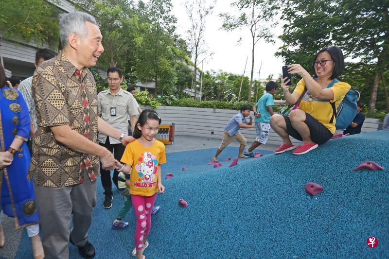 李显龙总理（左一）昨天为海军部村庄主持开幕时顺道参观内部设施如游乐场，并与居民近距离互动。（梁伟康摄）