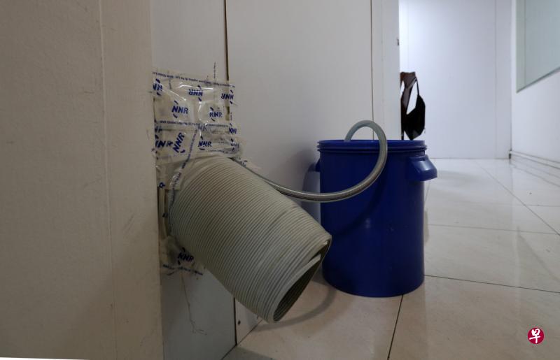 “猪仔屋”的每一个隔间都有冷气设备，一些冷气机的排水管连接到房间的水桶，租户必须定时倒掉桶里的水。（林泽锐摄）