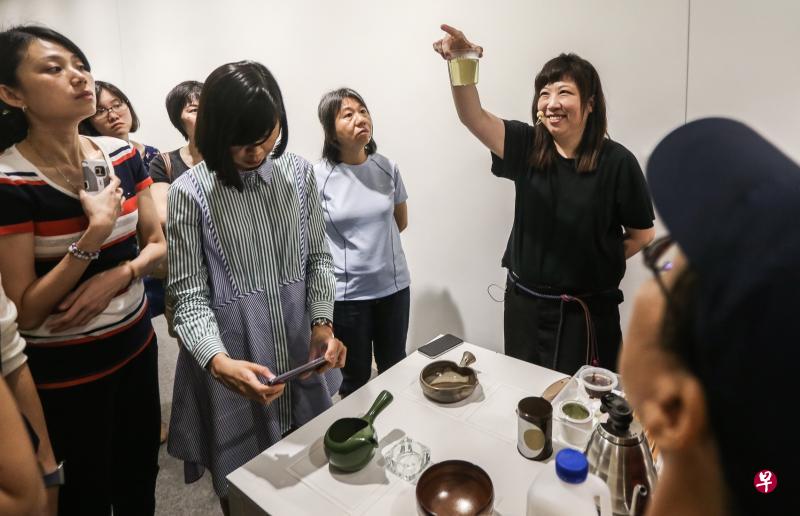 茶艺家陈春锦（举杯者）在品茶生活工坊上，向参与者示范如何观察、品茶以及观茶具等。（梁伟康摄）