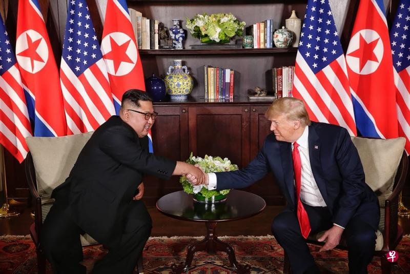朝鲜领袖金正恩与美国总统特朗普在特金会上演”世纪之握“。（法新社）