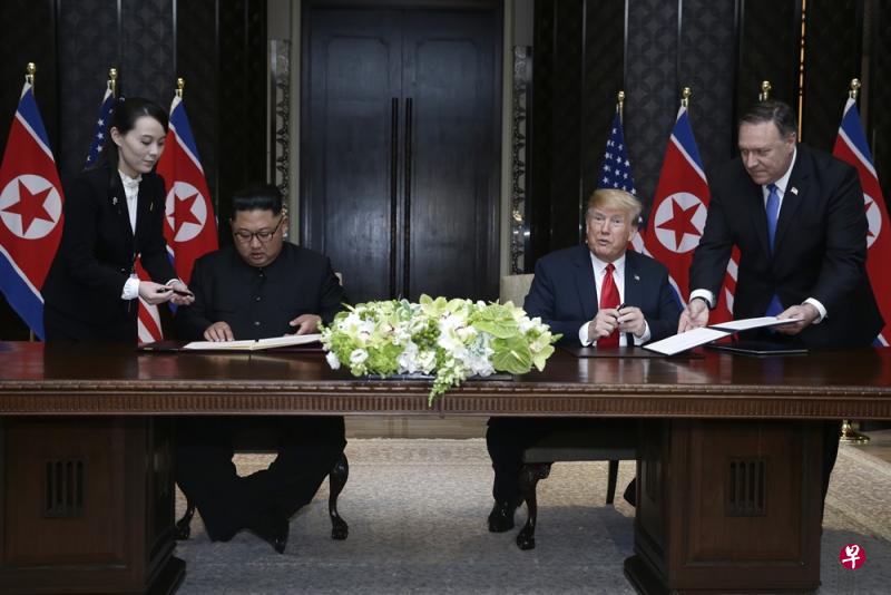 金正恩把特朗普准备的签名笔放在一旁，弃之不用，胞妹金以正递上“金笔”。（海峡时报）