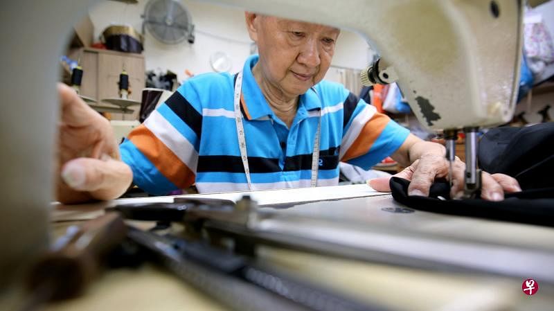 57年来，王钦祥一直守在缝纫机旁，以裁剪缝补衣服为生。（严宣融摄）