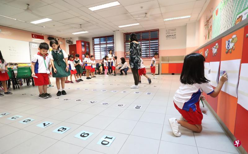 聚英小学数学教师通过游戏教学生加减法，把数字卡贴在地板上，让学生跳到正确的答案上面，让学生的学习体验更有趣。（陈来福摄）