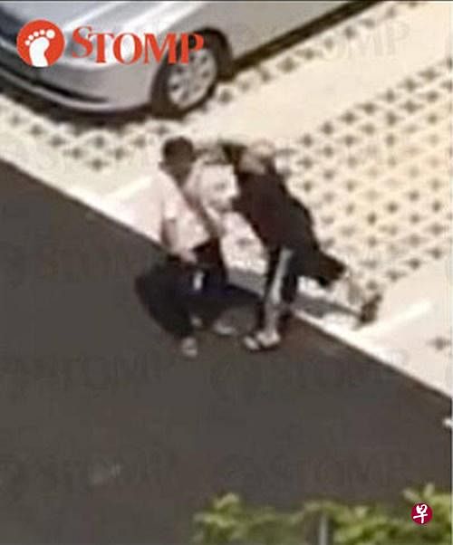 黑衣男殴打德士司机，导致司机摔倒在地上。（图/stomp） 