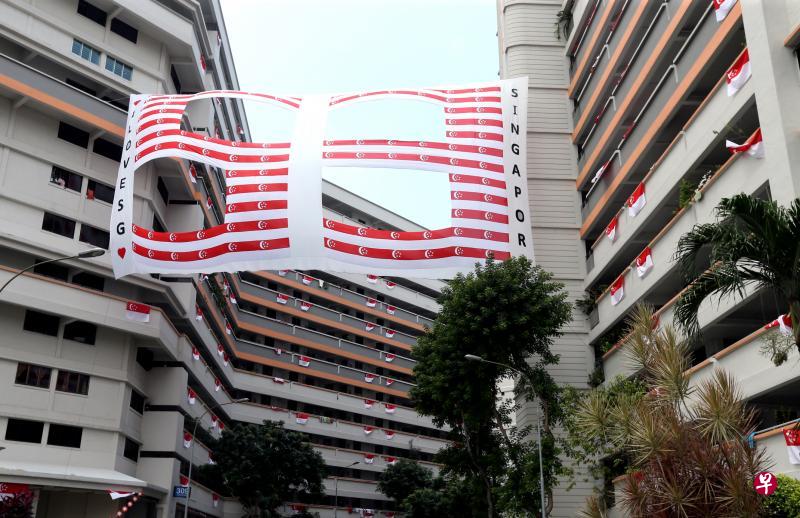 巨型造型国旗悬挂在顺福路第308和第309座组屋之间，呈现的“53”数字象征我国今年庆祝53岁生日。（邝启聪摄）