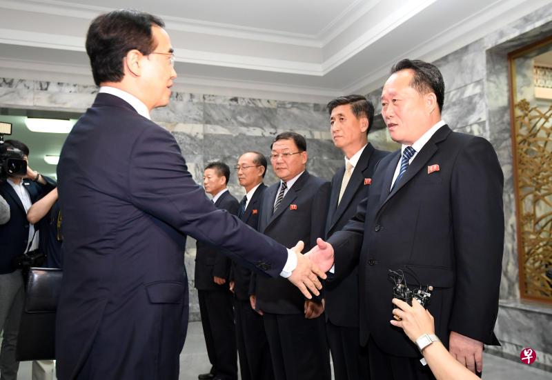 赵明均（左）与李善权在会前握手问好。（路透社）