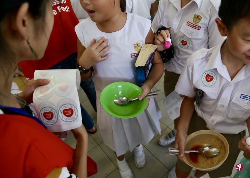 每一个吃完盘中食物的学生都会获得一张“我做到了空盘运动”的圆形贴纸与文具，以鼓励他们继续保持不浪费食物的好习惯。（严宣融摄）