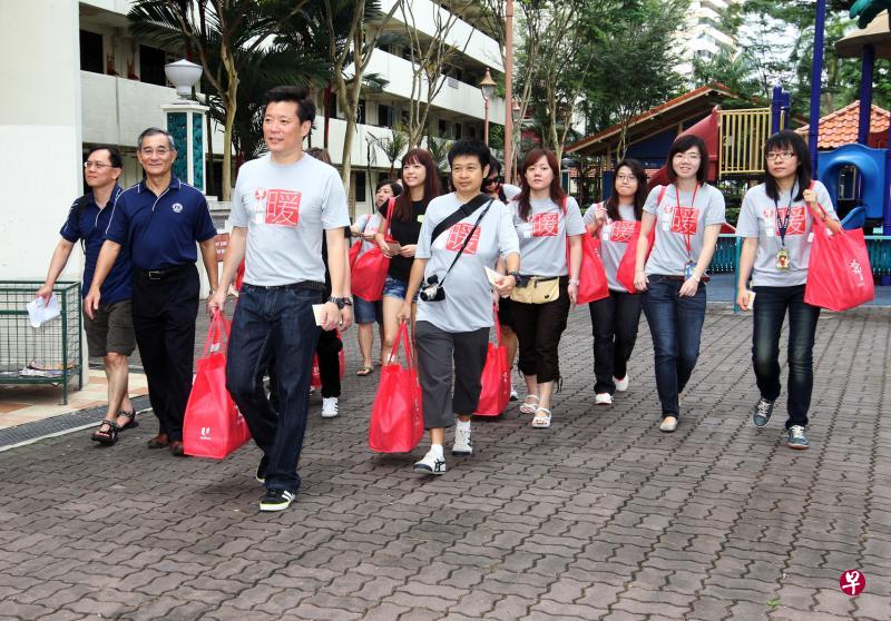在第一届“早报送暖”活动上，早报总编辑吴新迪（左二）和时任早报采访主任韩咏梅（左三）与40多名《联合早报》工作人员分别到五个组屋区为约200名独居老人送上新年礼包。（档案照片）