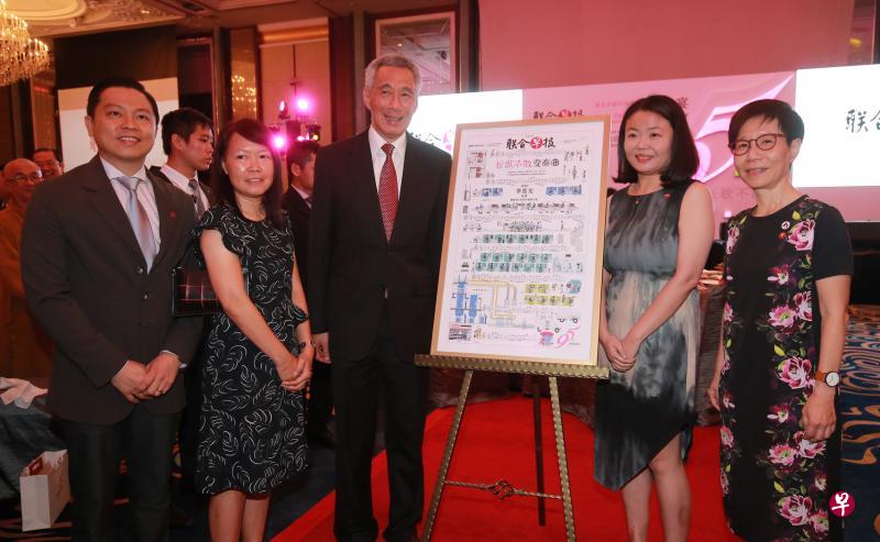 李显龙总理（中）昨晚在晚宴场边与新加坡报业控股华文媒体集团新闻中心副总编辑吴新慧（右起）、新闻中心采访副主任杨萌、《联合早报》副总编辑郭思满和早报视觉部主任陈聪明，在昨天出版的早报95周年纪念特刊版面旁留影。（唐家鸿摄）