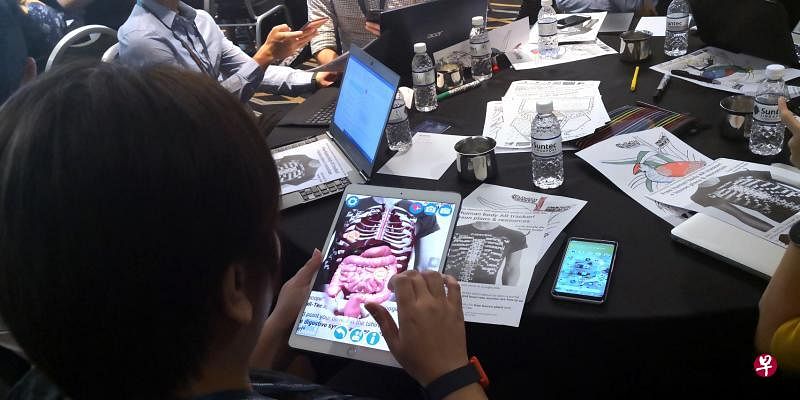 澳大利亚悉尼卫理公会女子学校教师布雷特，在亚洲教育科技展览会的工作坊上分享扩增实境和虚拟实境的教学应用，示范手机应用如何能把平面的人体器官立体化，辅助生物课教学。（洪亿隽摄）