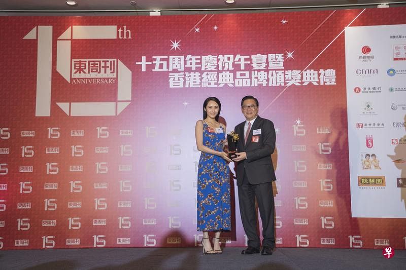 著名艺人汤怡（左）代表海马从香港行政会议成员林健锋手中领取“香港经典品牌”奖项。（商家提供）