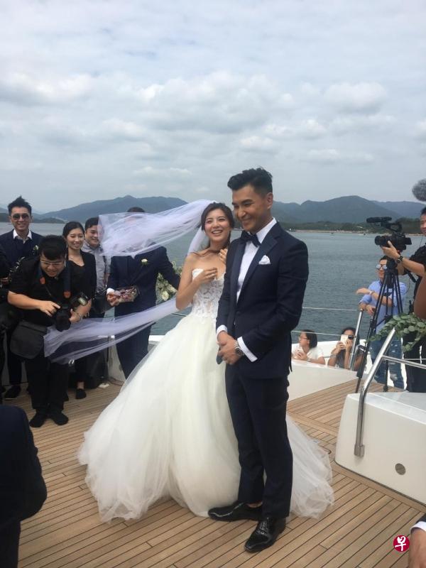 陈展鹏（左）、单文柔换上西装及婚纱，在游艇上举行婚礼。（互联网）