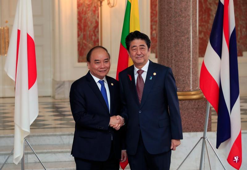 越南总理阮春福（左）本月初在东京出席日本与湄公河流域国家峰会时，与日本首相安倍晋三合照。（路透社）