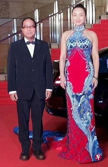 《三夫》的中国女星曾美慧孜拖着长长裙摆的“金鱼装”，走得步步惊心，导演陈果（左）红毯上不时要扶着她。（互联网）