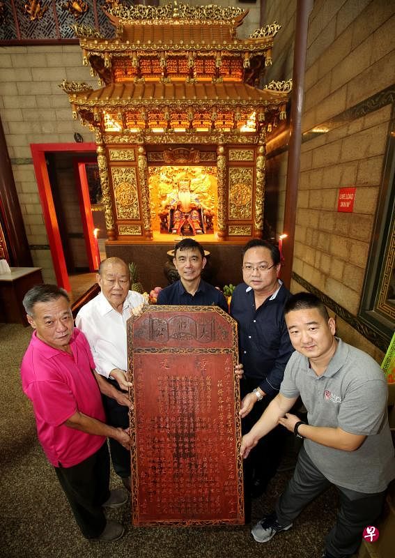 水廊头大伯公福德神庙找回113年前重修时所立的木匾。左起是水廊头大伯公庙总务林翼鹏、主席郑亚味、文史研究员吴庆辉、国大中文系高级研究员许源泰和中文系硕士生杨治中。（龙国雄摄）