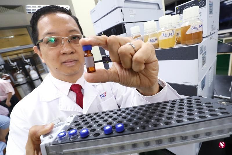 南洋理工化学与生命科学系副主任许明哲把洋参凉茶的样本放入高性能液箱色谱仪器进行测试。（陈来福摄）