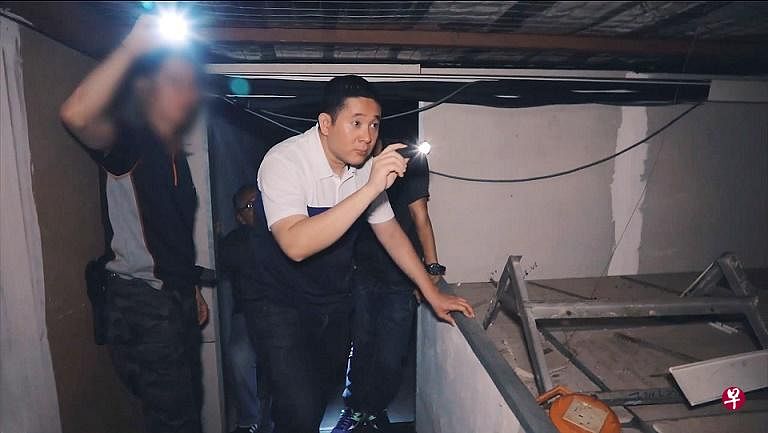 安宁·阿敏拿着手电筒跟着执法人员搜查店屋单位。（视频截图