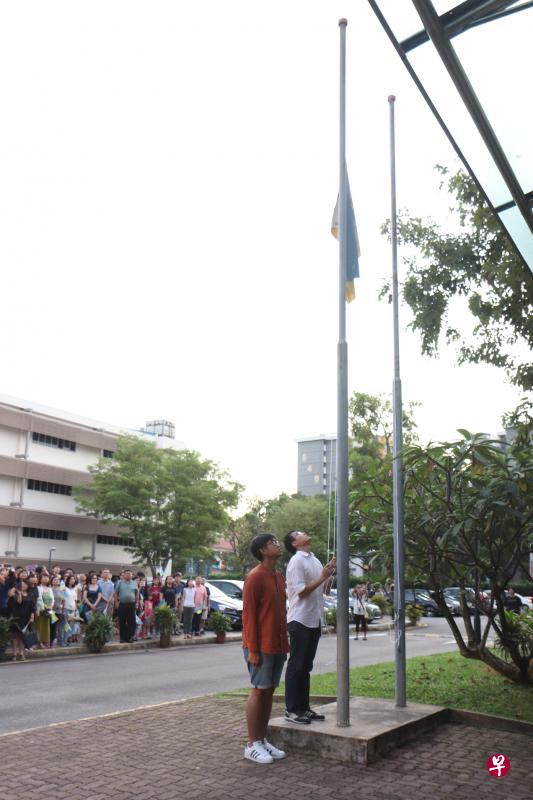 在响亮的校歌声中，降旗手张禾达降下校旗。（图片由安初提供）