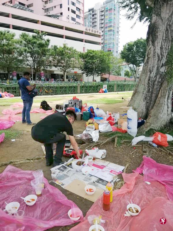 一名执法人员弯腰查看摆在地上的食物。（取自网络） 