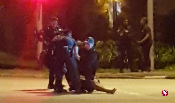 网传3名警员在马路中央抬起一名瘫坐着的男子，相信他是其中一名涉事的男子。（面簿照片）