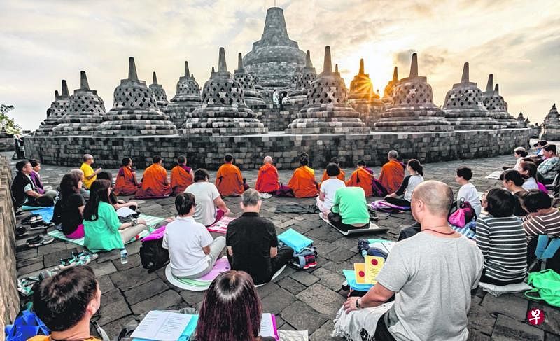 朝圣团面向第七至第十层佛塔，席地盘腿静坐，夕阳伴随他们平静的心缓缓西沉。