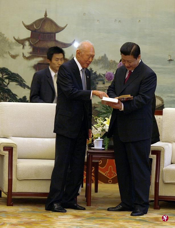 2008年8月7日，内阁资政李光耀以北京奥运开幕式嘉宾身份受邀访华。他在北京人民大会堂会晤了当时的中国国家副主席习近平（右）时，赠送一部他的《李光耀回忆录》给对方。（档案照片） 