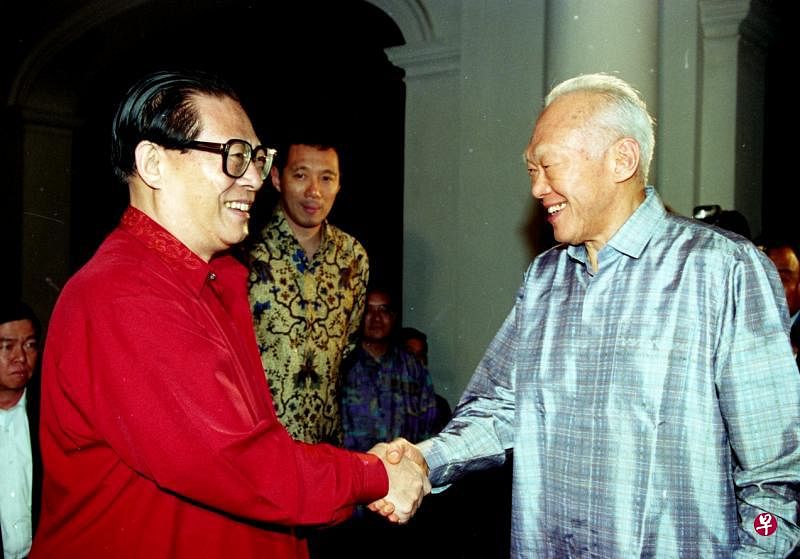 1994年11月8日，时任中国国家主席江泽民访问新加坡作为期三天的国事访问。当晚，李光耀资政在总统府内游泳池畔，设私人晚宴招待中国国家主席江泽民，两人见面时握手欢谈。中为当时的侍从部长李显龙副总理。（档案照片）