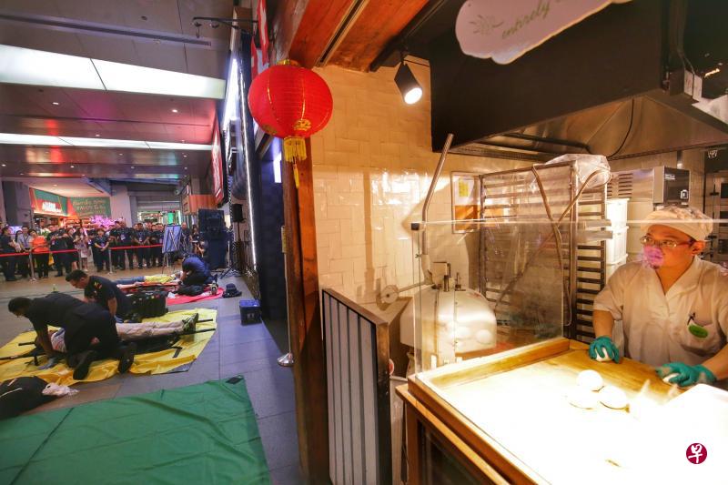 今年的“心跳演习”在商场举行，让商家也加入对抗恐怖袭击的行列。图为313@Somerset商场一家餐馆的面包师傅在演习的紧张氛围中，不忘继续捏面团。（林国明摄）