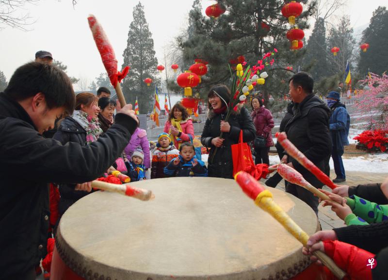 来八大处庙会祈福的人们争先敲起太平鼓。