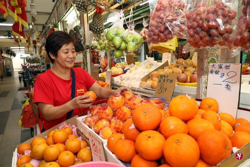 在大巴窑四巷第93座巴刹卖水果近40年的江惠敏相信，来临周末会有很多街坊前来购买年柑。（邝启聪摄）
