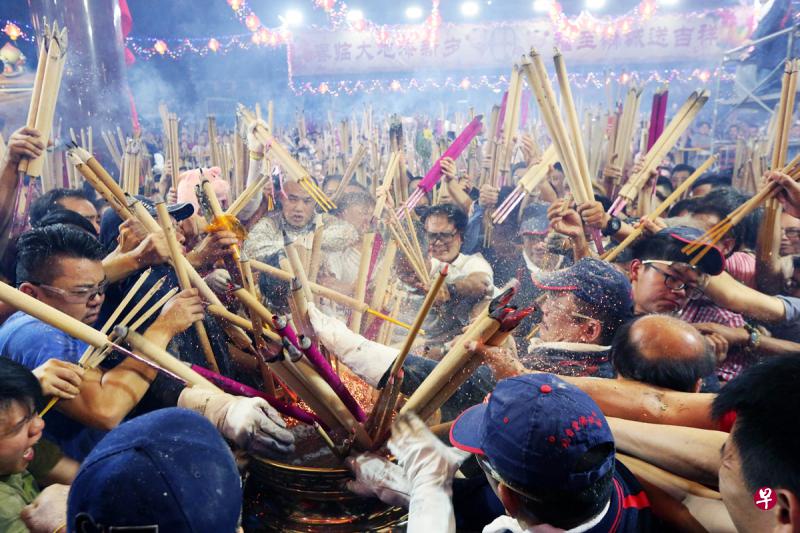 午夜一到，工作人员高喊一声“新年快乐”，众香客听到口令后，争先恐后把香插进香炉。（庄耿闻摄）