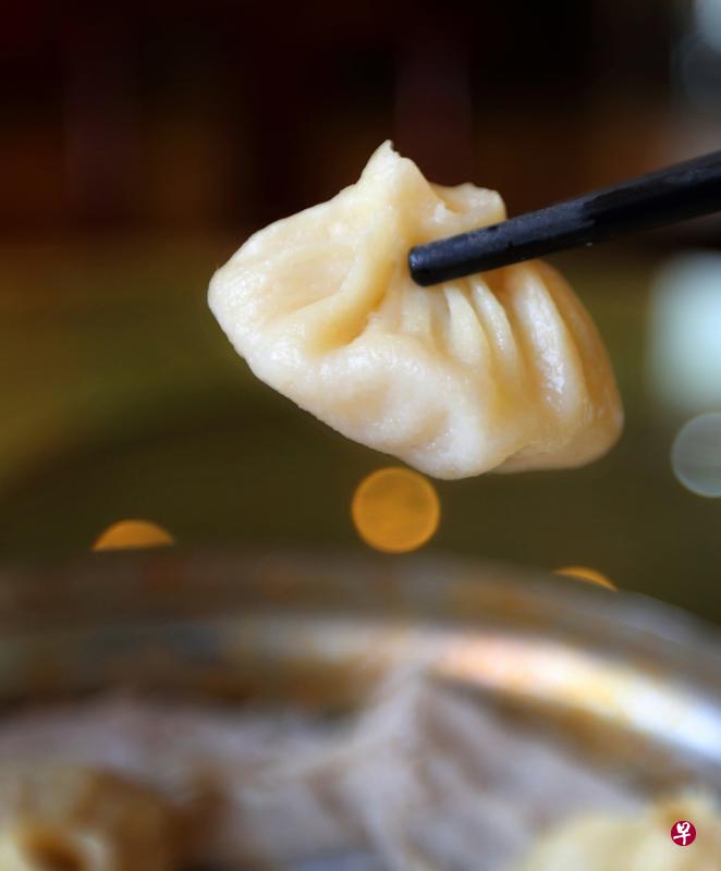 开封灌汤包子吃法讲究，轻轻提，满满移，先“开窗”（咬一小口），一口吃，后喝汤，满嘴香。（王远昌摄）