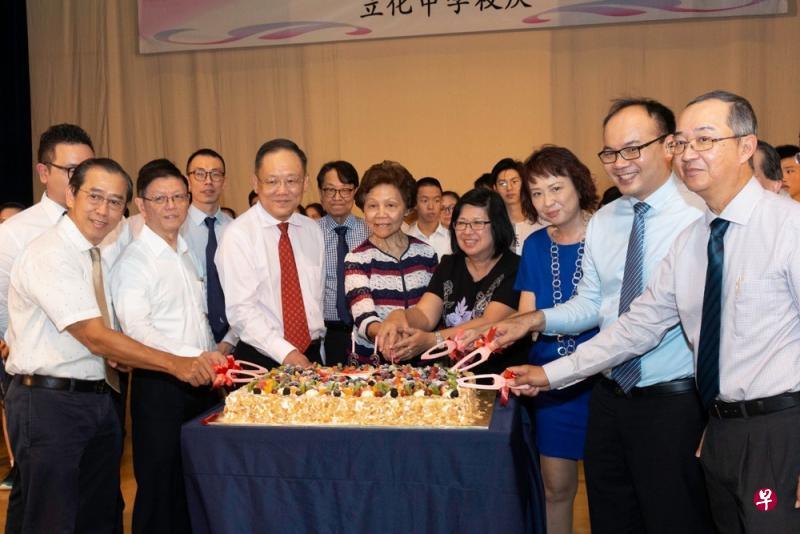 师长和校友上台与表演者一起合唱生日歌，切水果奶油蛋糕。（左起）立化中学咨询委员会委员陈奕车、咨询委员会副主席柯毓辉、咨询委员会主席林理明、退休校长梁环清、立化中学校长李惠棣、家长教师联谊会主席许木英、西区第七校群督导林文康、咨询委员会副主席陈亚九。（立化中学提供）