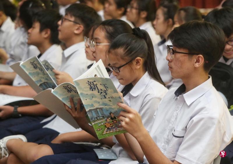 学生边听歌，边阅读歌本。（陈福洲摄）