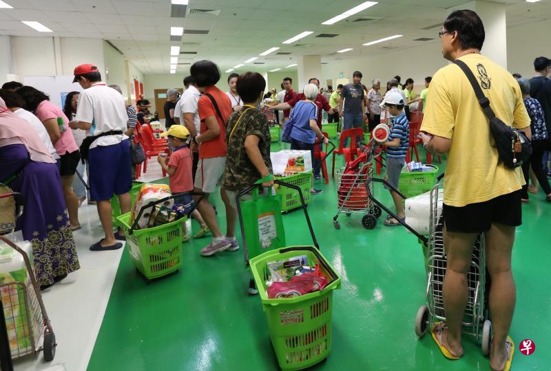 甘榜乌美—景万岸区多名居民昨天到菜市路亿达商业园筹办的临时超市购物，过程中有数名保健促进局培训的健康大使教导他们如何选购较健康食品。（庄耿闻摄）