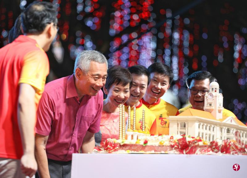 李显龙总理昨晚以主宾身份出席华侨中学百年校庆万人宴。图为总理致辞后上台为华中校庆蛋糕吹蜡烛。左三起为文化、社区及青年部长傅海燕、华中管委会主席林伟杰医生、贸工部兼教育部高级政务部长徐芳达，以及华中校友会会长黄龙金。（何家俊摄）