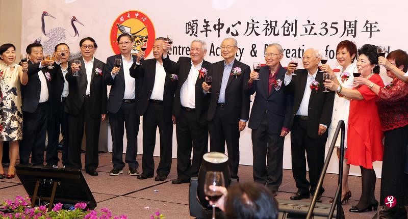 会长王邦文（右五）与理事们举杯敬酒，欢庆颐年中心35周年。（陈来福摄）