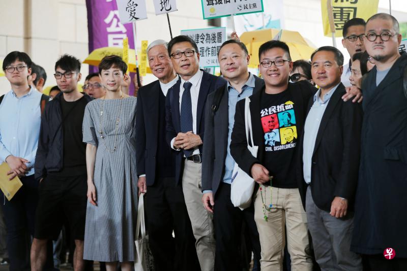 香港“占中”九名被告，左起为学联前常委张秀贤、学联前常务秘书钟耀华、公民党立法会议员陈淑庄、牧师朱耀明、中大教授陈健民、港大法律学者戴耀廷、社民连副主席黄浩铭、民主党前主席李永达及社福界立法会议员邵家臻。（路透社）