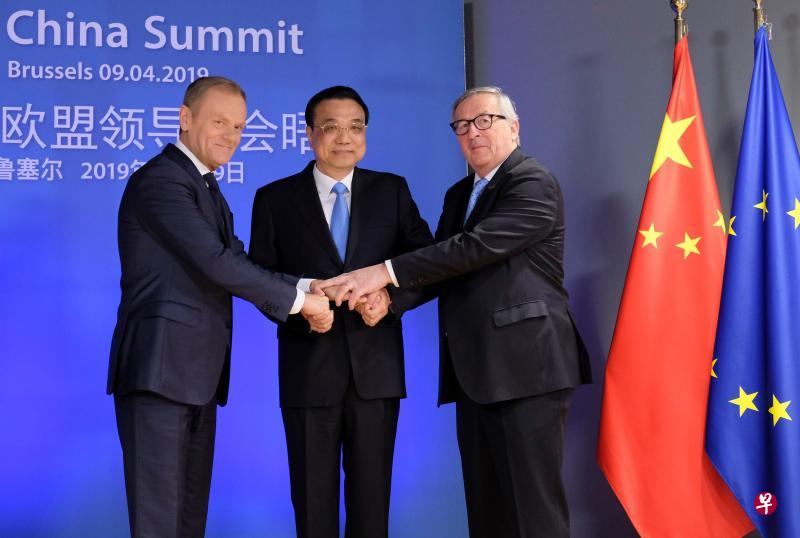 中国总理李克强（中）在峰会前受到欧洲理事会主席图斯克（左）和欧盟委员会主席容克的欢迎。（法新社）