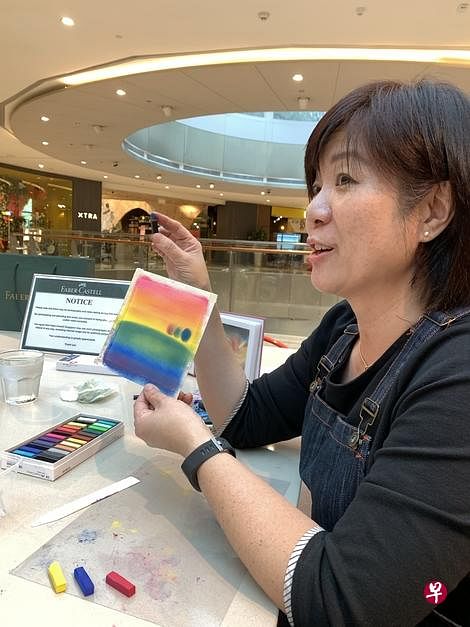 伍成就示范如何利用红、黄和蓝，以指尖画出彩虹七色。